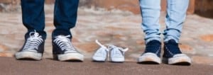 Two parents stand by empty small shoes