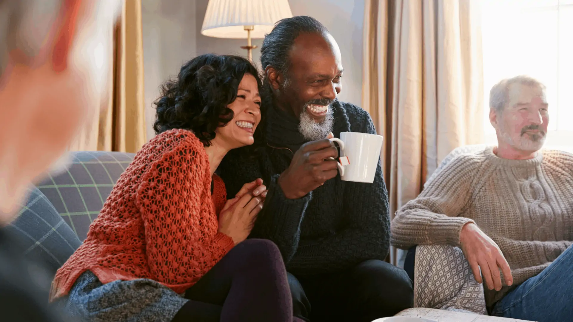 An older couple and their friend smile and look off camera. 