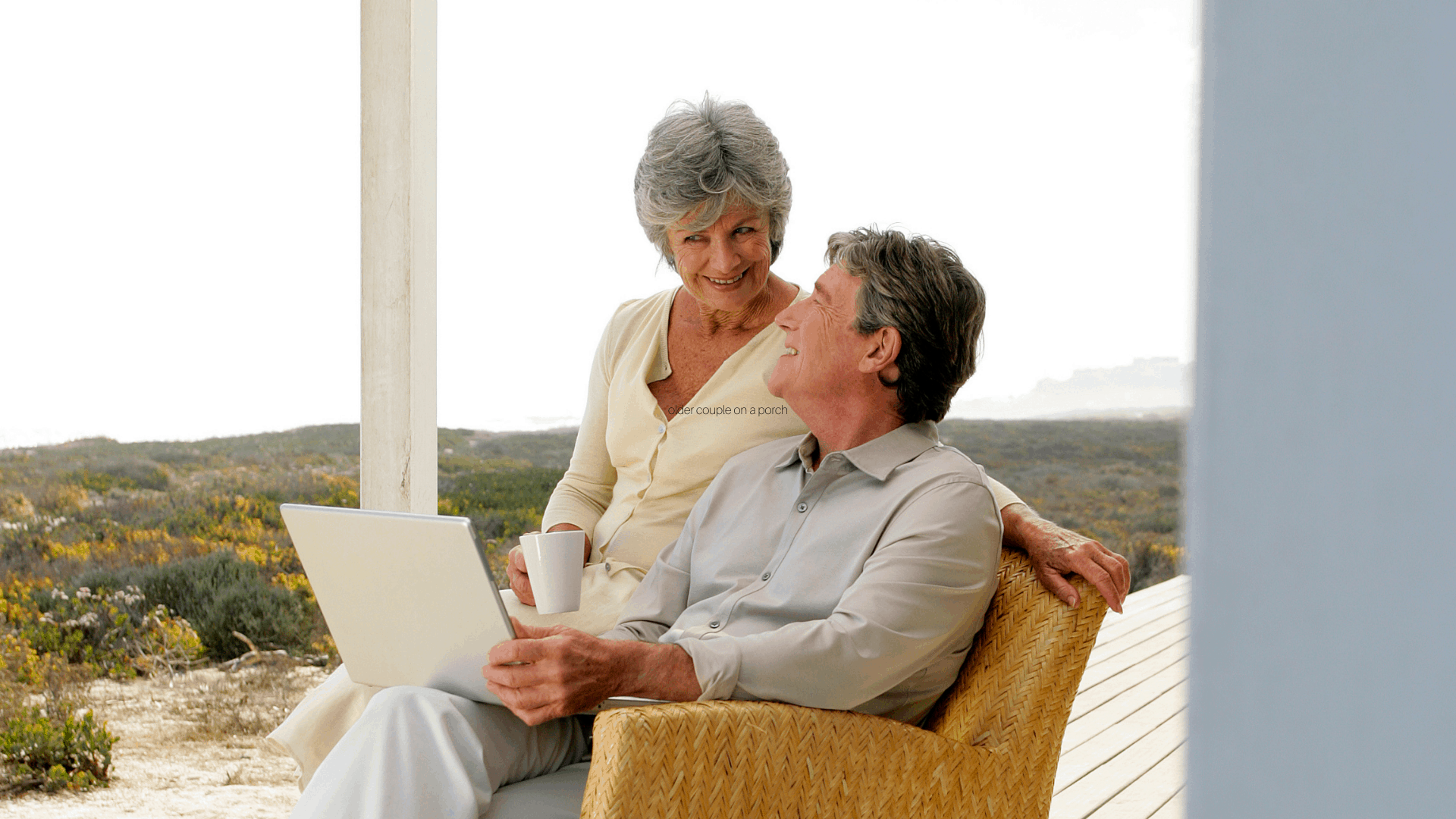 A happy couple sits in a chair together researching acupuncture and gentle e-stim therapies that pair well with it. 