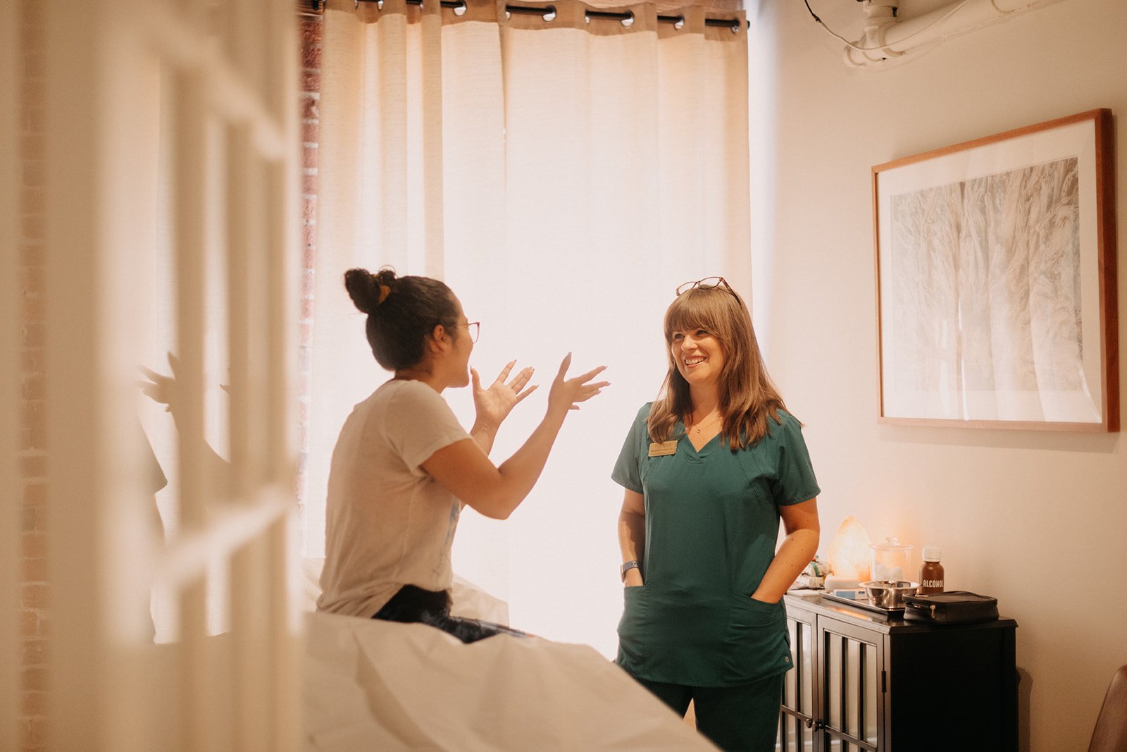 Acupuncturist listens to patient discussing how they are feeling after several months of treatment - they feel great.